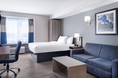 um quarto de hotel com uma cama e um sofá em Microtel Inn & Suites by Wyndham Kanata Ottawa West em Kanata