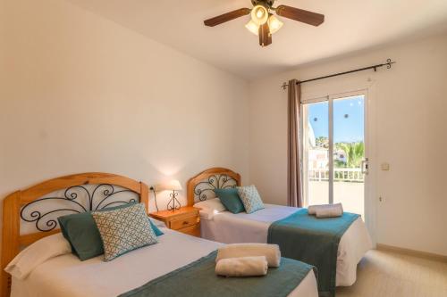 a bedroom with two beds and a ceiling fan at Puerto de Alcudia -2765 Mallorca in Port d'Alcudia