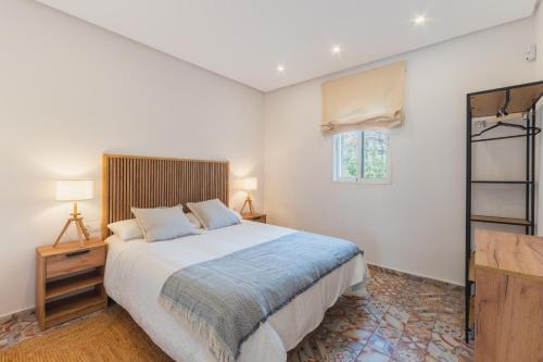 um quarto com uma cama grande e uma janela em Manolete apartamento em Jerez de la Frontera