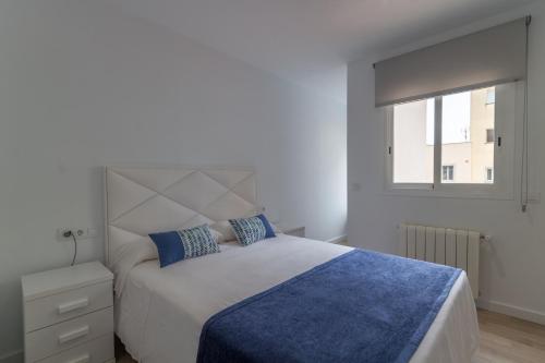 sypialnia z łóżkiem z niebieskim kocem i oknem w obiekcie Palma -2702 Mallorca w Palma de Mallorca