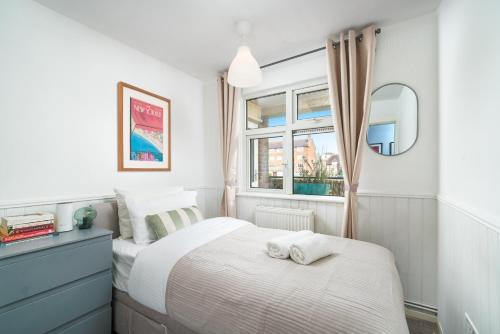 una camera da letto con un letto e due asciugamani di Gorgeous 3 Bedroom flat In London on Central Line for Families, Contractors, Business Travellers a Woodford Green