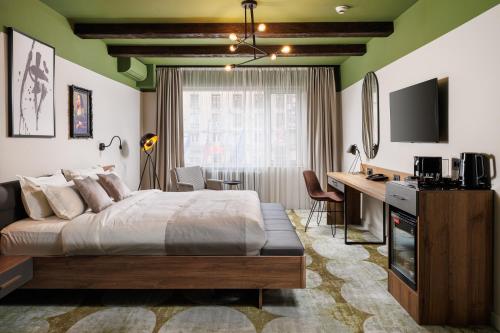 1 dormitorio con 1 cama y escritorio con ordenador en Bucharest Comfort Suites Hotel, en Bucarest