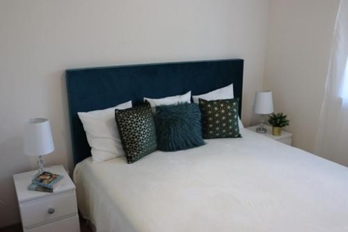 Un dormitorio con una gran cama blanca con almohadas. en Tündérkert Villa, en Balatonfőkajár
