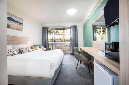 a hotel room with a large bed and a desk at Nightcap at Roxby Downs in Roxby Downs