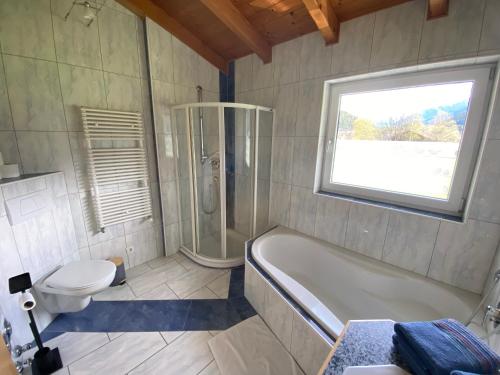 a bathroom with a tub and a toilet and a shower at Ferienwohnung Mark-Oehmen in Imst