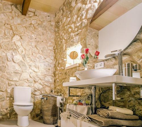 a stone bathroom with a sink and a toilet at Lloret de vistalegre -3065 Mallorca in Lloret de Vistalegre