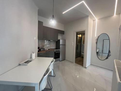 a white kitchen with a table and a mirror at Ladadika Fine Living in Thessaloniki