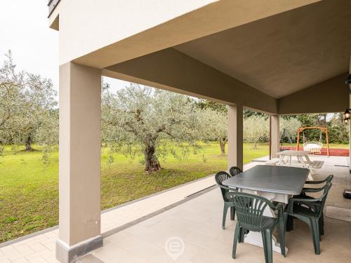 a patio with a table and chairs on a porch at Estay - Garden Paradise Escape - BBQ AirCon in Baratili San Pietro