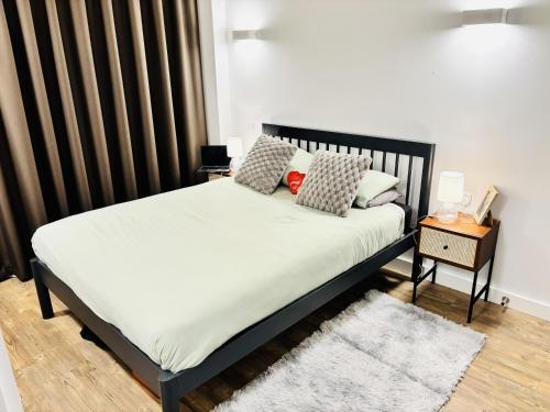 a bedroom with a bed with a black headboard at Your London Escape Luxurious 1 Bedroom Apartment in London