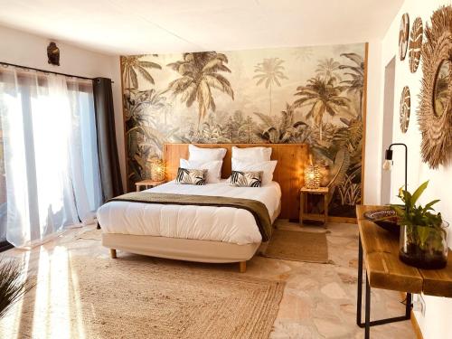 1 dormitorio con 1 cama grande y un mural de palmeras en Le Mas de San Lou, en Cabasse