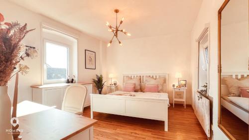 1 dormitorio con cama blanca y almohadas rosas en Zentrales Turm-Apt mit Terrasse en Amberg