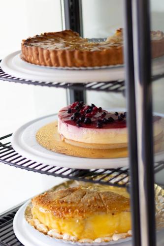 a rack with various pastries and pies on plates at Alborán Algeciras in Algeciras