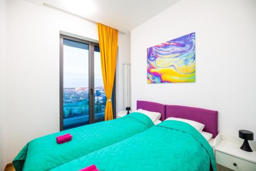 een slaapkamer met 2 bedden en een schilderij aan de muur bij CheckBelgradeApartments - Colors in Belgrado
