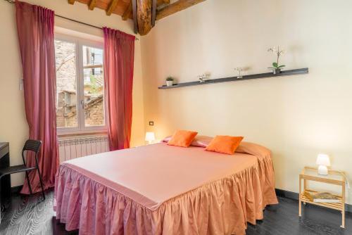 - une chambre avec un lit doté d'oreillers orange et une fenêtre dans l'établissement Fly To Home Siena Centre, à Sienne