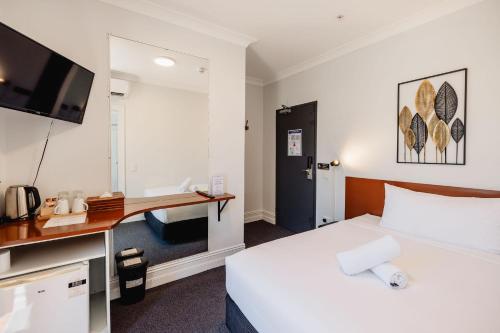 a hotel room with a bed and a desk at Newtown Cozy Stays in Sydney