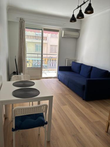 un salon avec un canapé bleu et une table dans l'établissement Studio 2 étoiles à Menton pour 4 personnes, à Menton