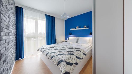 ein Schlafzimmer mit einer Wand mit blauen Akzenten und einem Bett in der Unterkunft Apartamenty Sun & Snow Kuracyjna 15A in Jastrzębia Góra