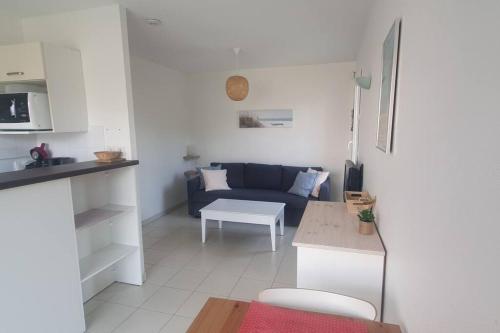 een woonkamer met een blauwe bank en een tafel bij Studio en résidence avec piscine - 2820 in Soulac-sur-Mer