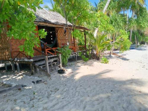 a small hut on a beach with trees at Fam Homestay in Fam