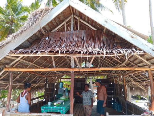 a group of people standing outside of a straw hut at Fam Homestay in Fam