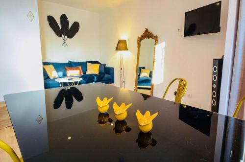 a living room with a table with three birds on it at Appartements de charme - Vidéoprojecteur et SPA en centre ville in Montpellier