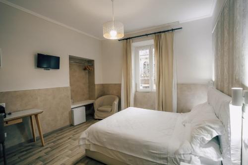 Dormitorio con cama, escritorio y TV en Mirabilia House Termini, en Roma