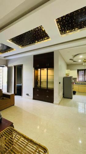 a large living room with a kitchen and a refrigerator at Shashi Farms for pool parties and stays in Gurgaon