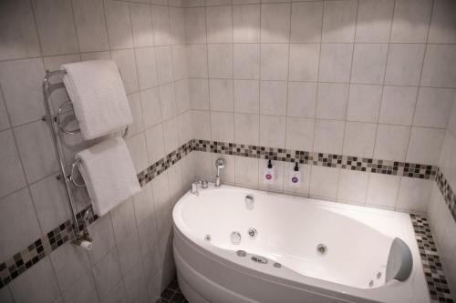 a white bathroom with a tub and a toilet at Quality Hotel Galaxen in Borlänge