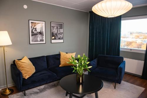 a living room with a blue couch and a table at Quality Hotel Galaxen in Borlänge