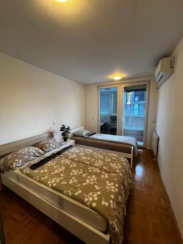 2 letti in una piccola camera con finestra di Apartment with Big Balcony and Parking Garage a Lubiana