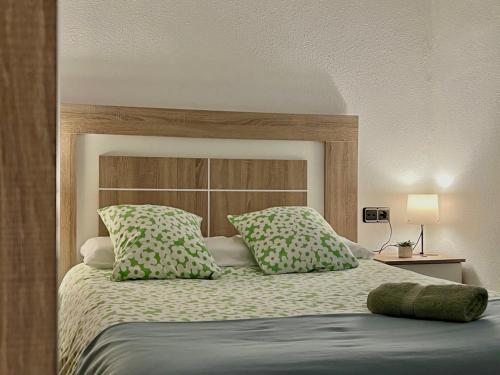 a bedroom with a large bed with green pillows at Blue et Rose by ARoom VUT-LE-966 in León