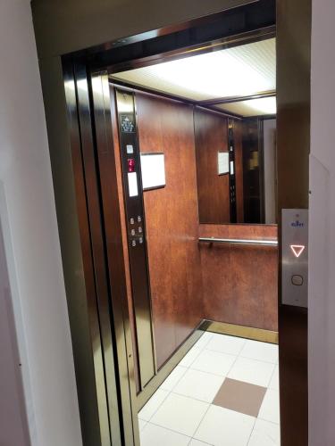 a glass elevator door in a building with a mirror at Hotel Margit in Trenčianske Teplice