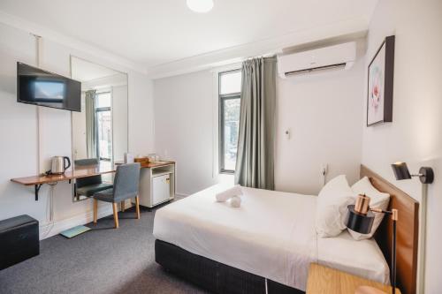 Schlafzimmer mit einem Bett und einem Schreibtisch mit einem Computer in der Unterkunft Newtown Cozy Stays in Sydney