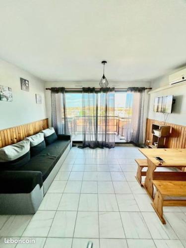 een woonkamer met een bank en een tafel bij Appartement vue MER Valras plage in Valras-Plage