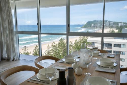 a dining room table with a view of the beach at Cashelmara Beachfront Apartments in Gold Coast