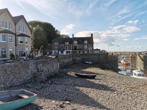 a stone bridge over a river with boats on the shore at Harbour House Studio, Porlock Weir in Culbone