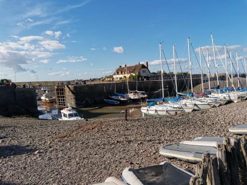a group of boats docked on a rocky beach at Harbour House Studio, Porlock Weir in Culbone