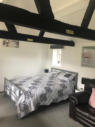 - une chambre avec un lit et un canapé dans l'établissement Robyns Nest, self catering cottage, à Welshpool