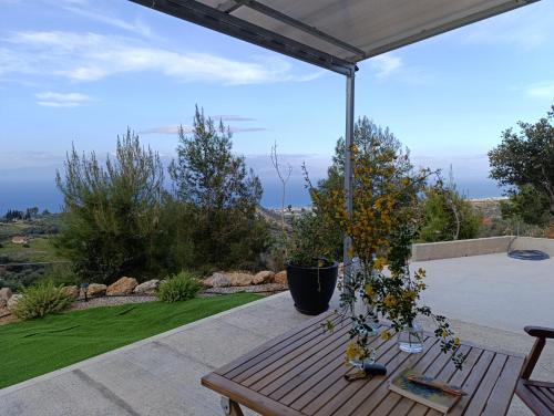a wooden bench on a patio with a view at Altheas Maisonettes in Xylokastron