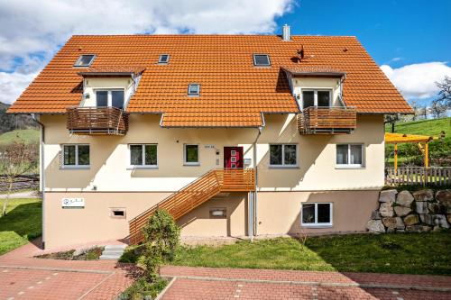 uma casa com um telhado laranja em Ferienhof Vordere Alm em Oberkirch
