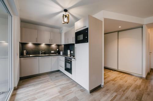 a kitchen with white cabinets and a ceiling at Résidence Les Charmes in Boofzheim