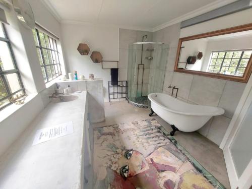uma casa de banho com uma banheira e um lavatório e uma banheira em Lieu De Grace em Joanesburgo