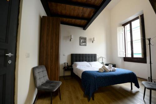 a bedroom with a bed with a blue blanket and a chair at Palazzo Oliveto in Florence