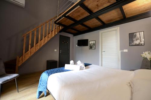 a bedroom with a large white bed and a staircase at Palazzo Oliveto in Florence