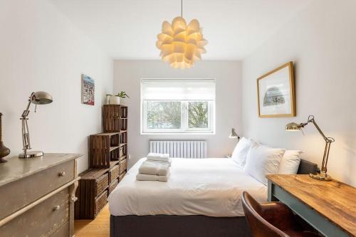 a bedroom with a bed and a desk and a window at 2BR w park-view in S Newington in London