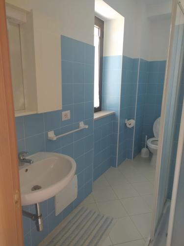 Baño azul con lavabo y aseo en Casa Italia en Oratino