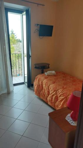 a bedroom with a bed and a balcony with a window at Casa Italia in Oratino