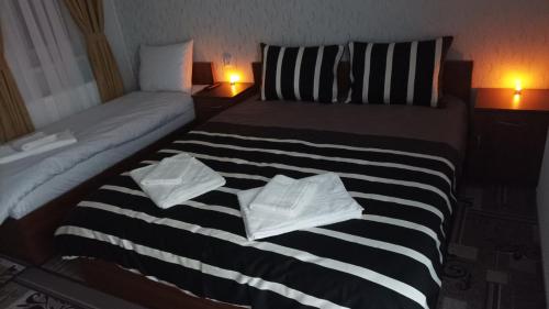 1 dormitorio con 2 camas y toallas blancas. en Готель Ассоль, en Khmelʼnytsʼkyy