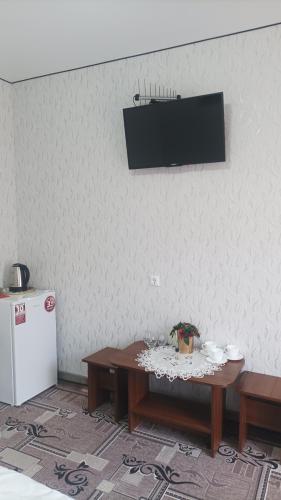 a room with a table and a tv on the wall at Готель Ассоль in Khmelʼnytsʼkyy