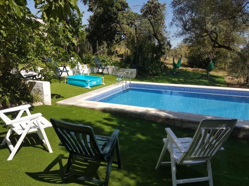two chairs and a swimming pool in a yard at Casa de la Fuente in Almonaster la Real